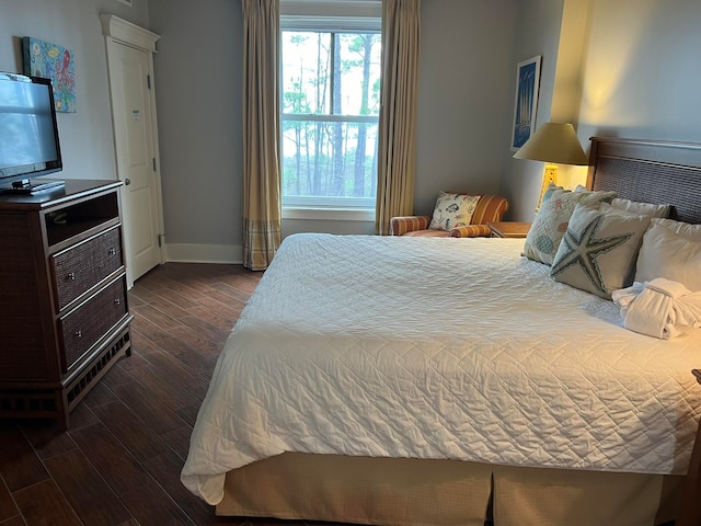 bedroom featuring dark wood-style floors and baseboards