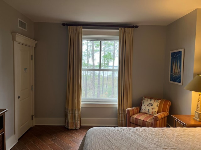 bedroom featuring visible vents, dark wood finished floors, baseboards, and multiple windows