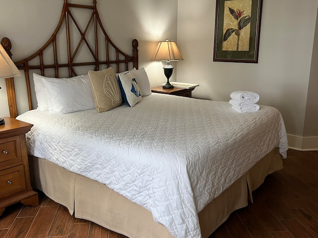 bedroom featuring baseboards and wood tiled floor