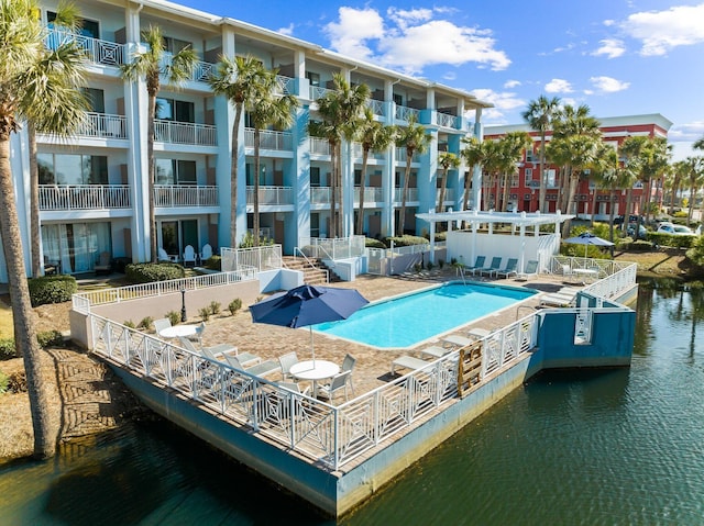 exterior space featuring a community pool, a water view, and a balcony