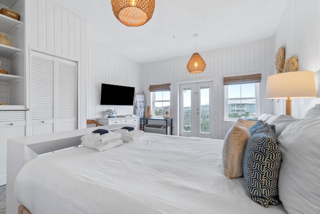 bedroom with a closet, french doors, and a notable chandelier