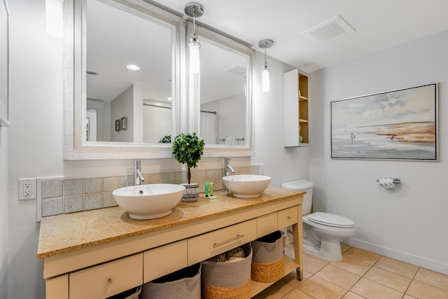 bathroom featuring tile flooring, double vanity, backsplash, and toilet