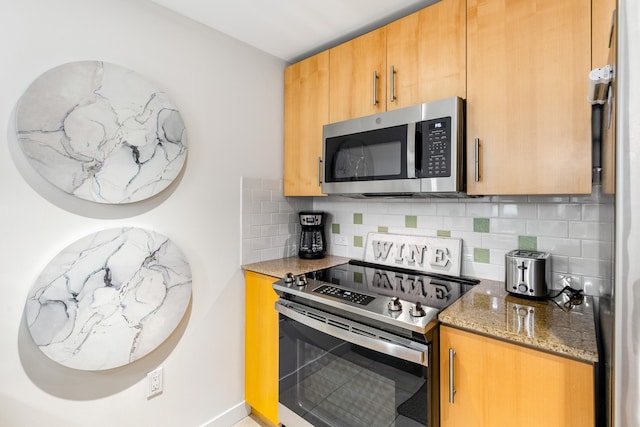 kitchen with appliances with stainless steel finishes, tasteful backsplash, and stone countertops