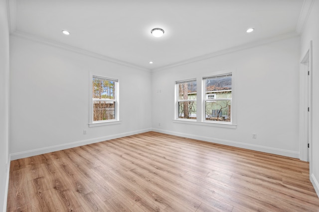 empty room with crown molding and light wood-type flooring