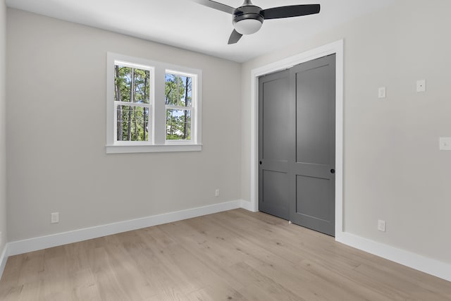 unfurnished bedroom with ceiling fan, light hardwood / wood-style flooring, and a closet