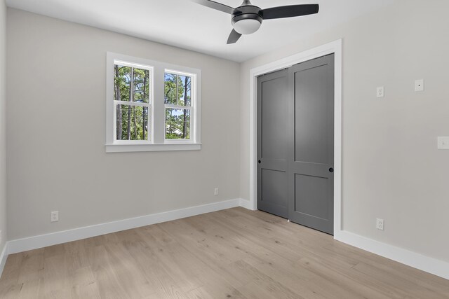 112 S Magnolia Beach Way, Santa Rosa Beach, FL 32459 - unfurnished bedroom featuring baseboards, light wood finished floors, a closet, and ceiling fan