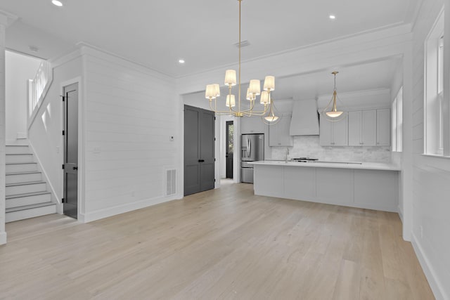 kitchen with stainless steel fridge with ice dispenser, tasteful backsplash, kitchen peninsula, hanging light fixtures, and light hardwood / wood-style flooring