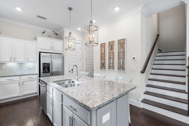 kitchen with a kitchen island with sink, dark hardwood / wood-style flooring, white cabinetry, stainless steel appliances, and sink