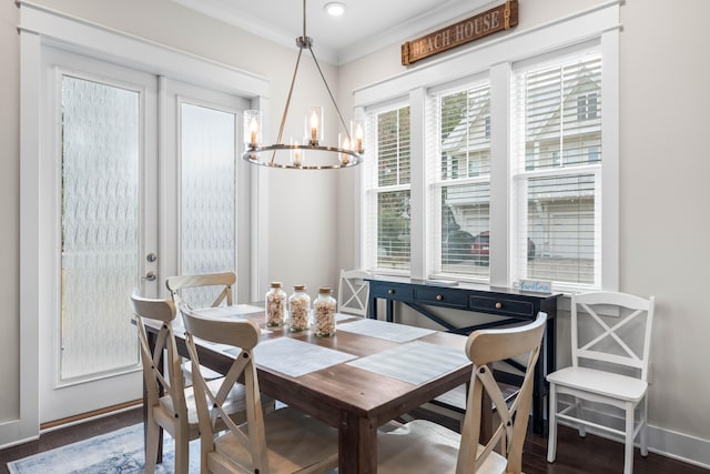 dining area with dark wood-type flooring, a chandelier, and ornamental molding