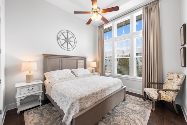 bedroom with dark hardwood / wood-style flooring, ceiling fan, and multiple windows