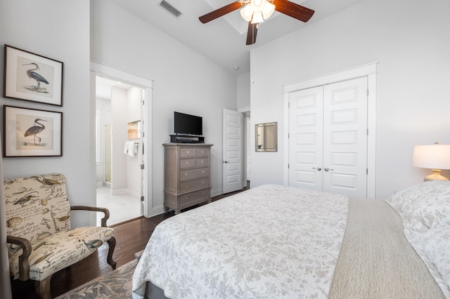 bedroom with a closet, dark hardwood / wood-style floors, ceiling fan, and lofted ceiling