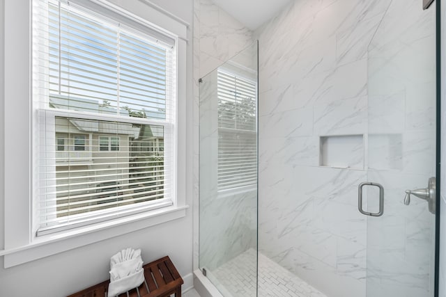 bathroom featuring plenty of natural light and a shower with door