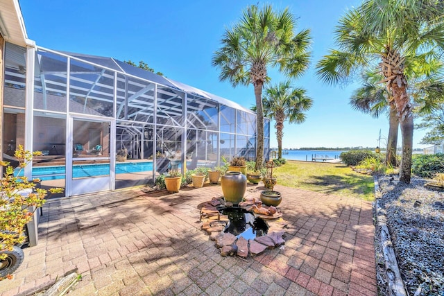 view of patio / terrace with a water view and a lanai