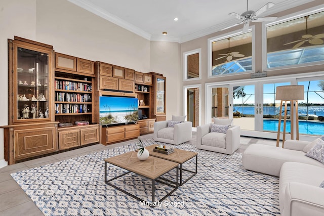 living room featuring light tile patterned floors, crown molding, ceiling fan, a towering ceiling, and french doors