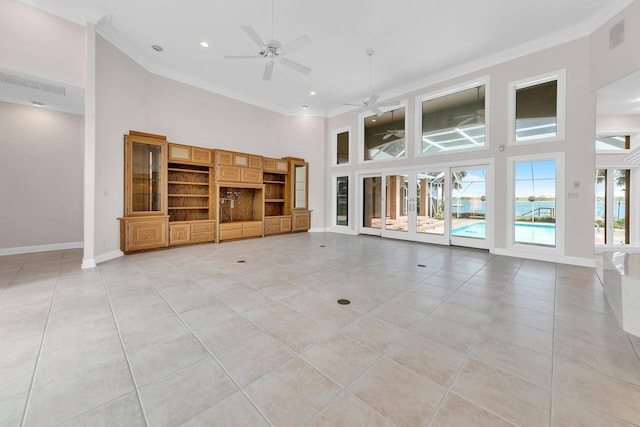 unfurnished living room featuring a high ceiling, ornamental molding, light tile patterned flooring, and ceiling fan