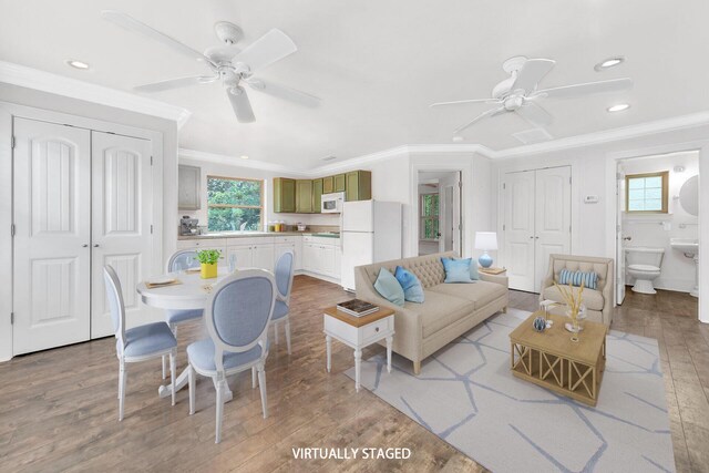 living room featuring crown molding, ceiling fan, and light hardwood / wood-style flooring