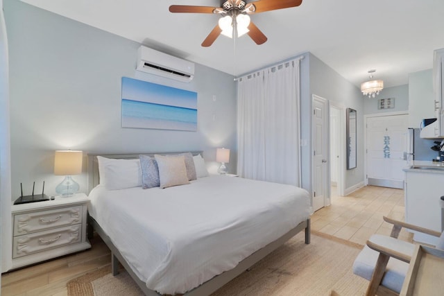 bedroom featuring white refrigerator, ceiling fan with notable chandelier, light wood-type flooring, and an AC wall unit