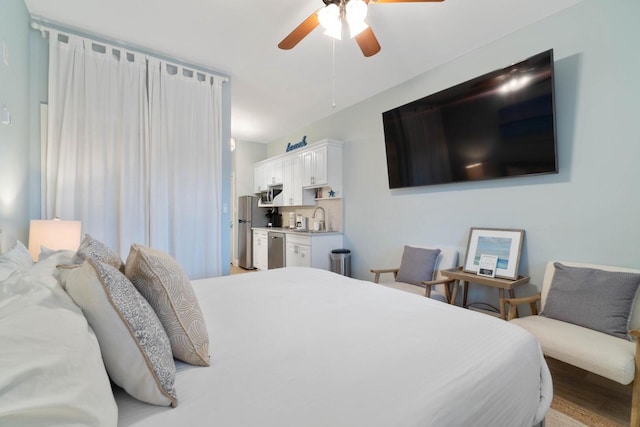 bedroom featuring stainless steel fridge, light hardwood / wood-style floors, ceiling fan, and sink