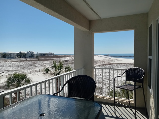 balcony with a water view and a beach view