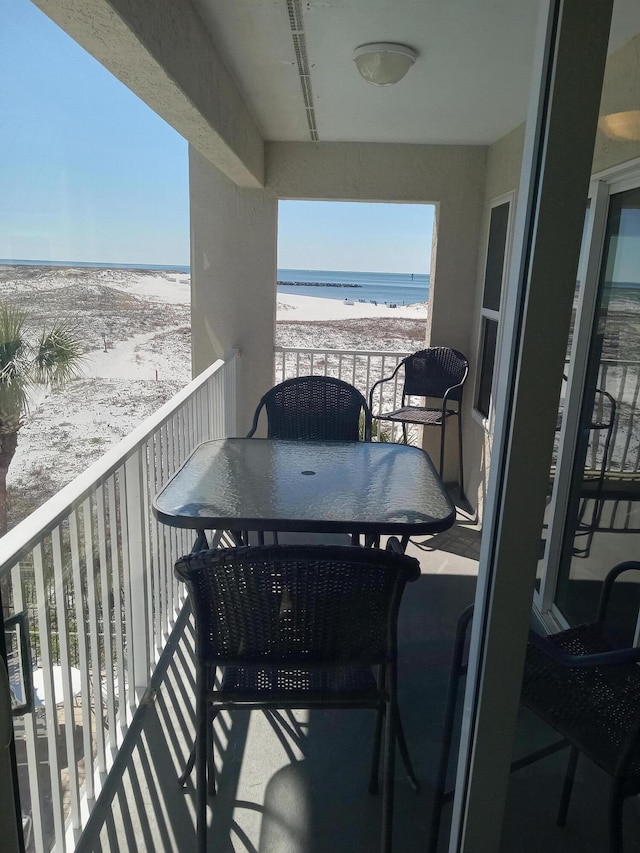 balcony featuring a water view and a beach view