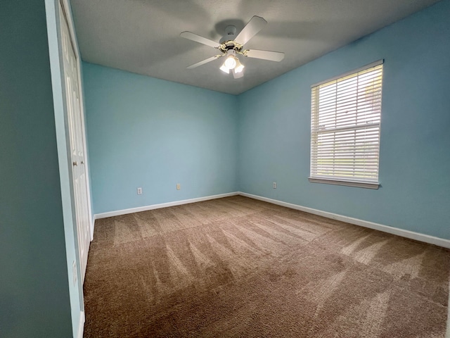 carpeted spare room with ceiling fan