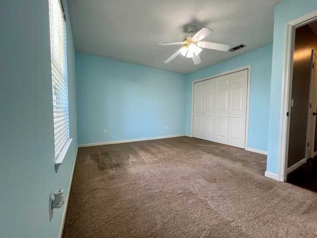 unfurnished bedroom featuring a closet, carpet, and ceiling fan