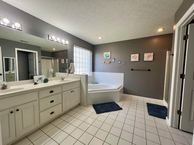 bathroom featuring vanity, separate shower and tub, tile patterned flooring, and a textured ceiling