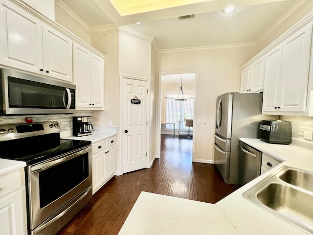 kitchen with dark hardwood / wood-style floors, appliances with stainless steel finishes, backsplash, and white cabinetry