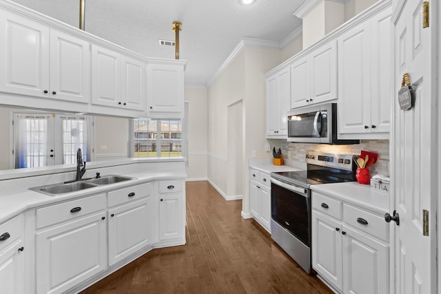 kitchen with white cabinetry, appliances with stainless steel finishes, sink, and crown molding