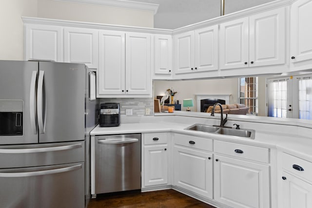 kitchen featuring stainless steel appliances, sink, dark wood-type flooring, white cabinets, and decorative backsplash