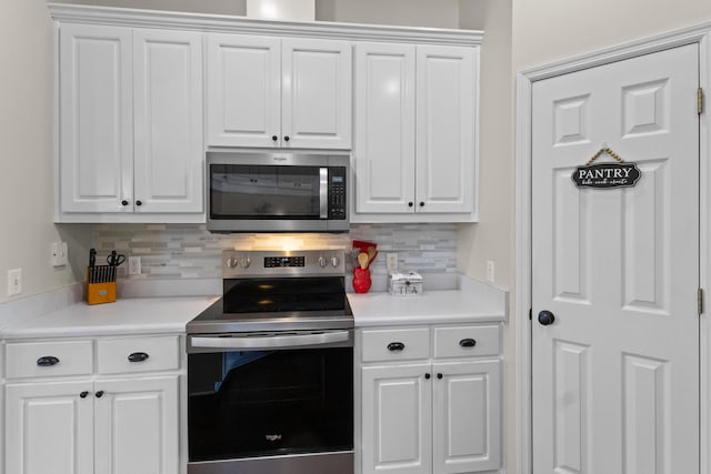 kitchen with white cabinets, tasteful backsplash, and stainless steel appliances