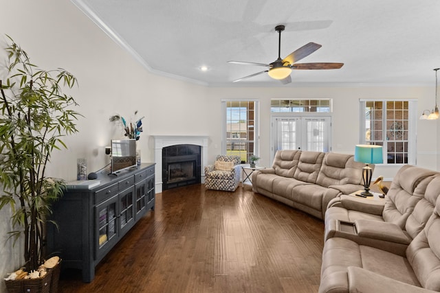 living room featuring french doors, ceiling fan, a fireplace, ornamental molding, and dark hardwood / wood-style floors