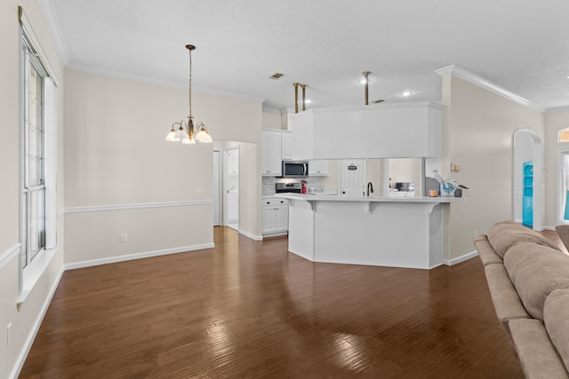 kitchen with a kitchen bar, white cabinetry, pendant lighting, and dark wood-type flooring