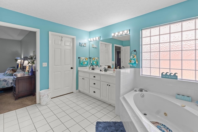 bathroom with tiled bath, tile patterned floors, a textured ceiling, and vanity