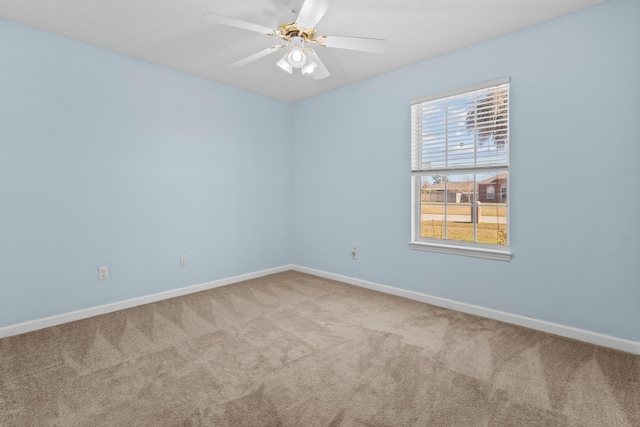 carpeted spare room featuring ceiling fan