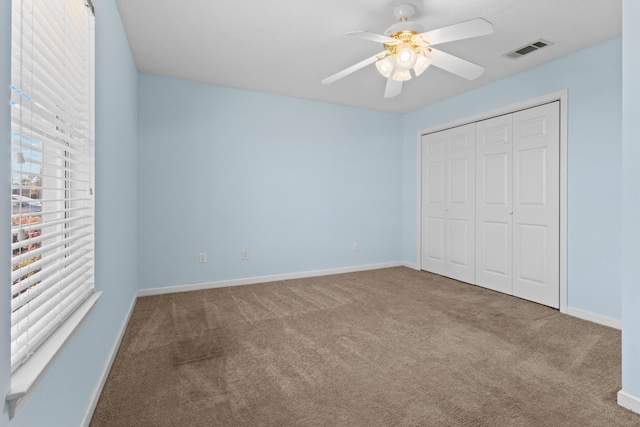 unfurnished bedroom with carpet, a closet, and ceiling fan