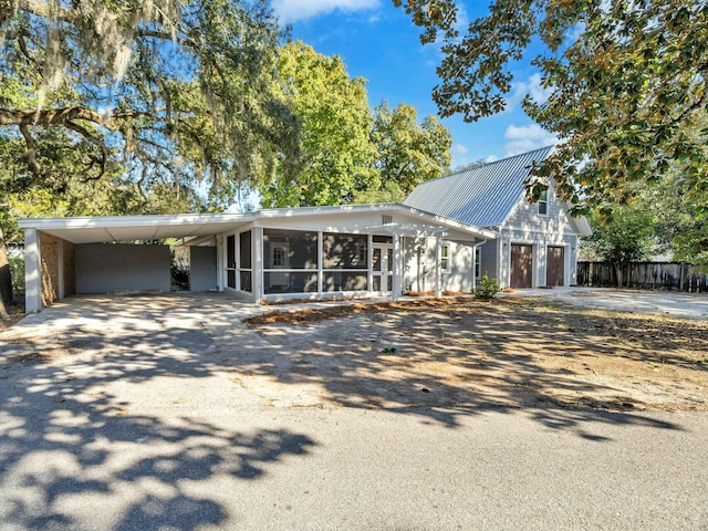 view of front facade with a sunroom, a garage, and a carport