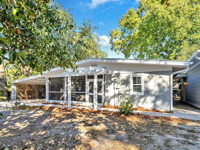 back of house featuring a carport and a sunroom