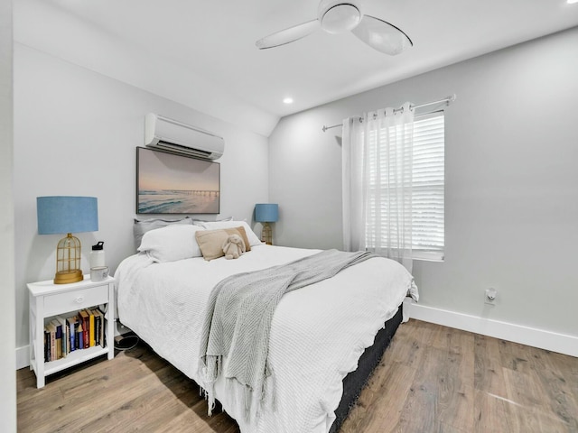 bedroom with a wall mounted AC, wood-type flooring, ceiling fan, and lofted ceiling