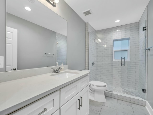 bathroom with vanity, toilet, and a shower with shower door