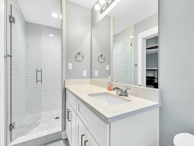 bathroom with vanity, toilet, and a shower with shower door