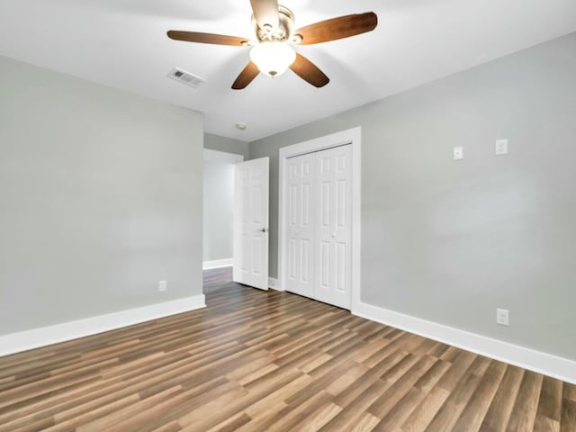 unfurnished bedroom with a closet, hardwood / wood-style flooring, and ceiling fan