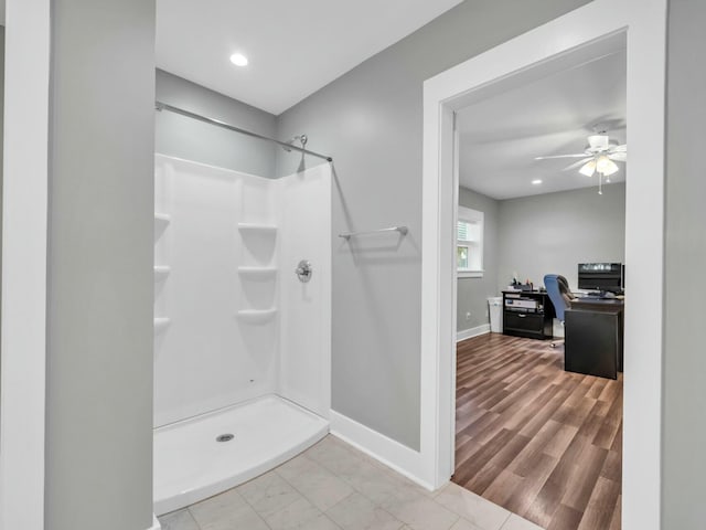 bathroom featuring ceiling fan, wood-type flooring, and walk in shower