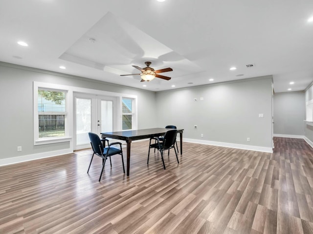 dining area with french doors, crown molding, ceiling fan, light wood-type flooring, and a tray ceiling