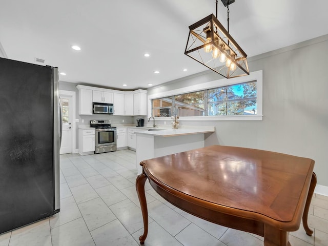 kitchen with white cabinets, decorative light fixtures, stainless steel appliances, and ornamental molding