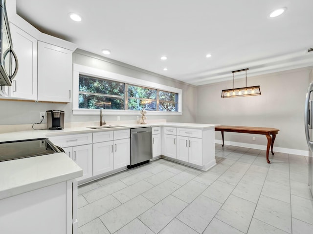 kitchen with kitchen peninsula, appliances with stainless steel finishes, sink, decorative light fixtures, and white cabinetry