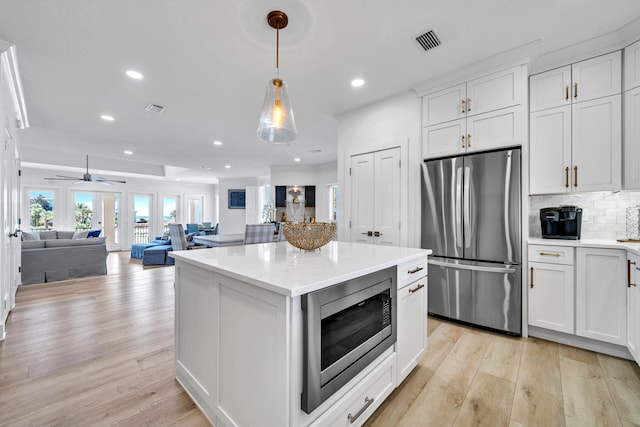 kitchen with ceiling fan, light hardwood / wood-style flooring, stainless steel appliances, and white cabinetry