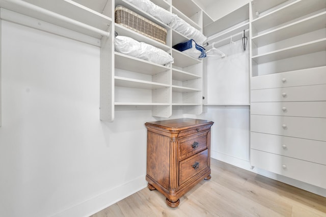 walk in closet with light hardwood / wood-style floors