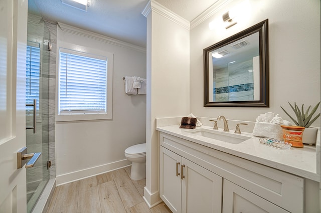 bathroom with walk in shower, vanity, ornamental molding, hardwood / wood-style flooring, and toilet