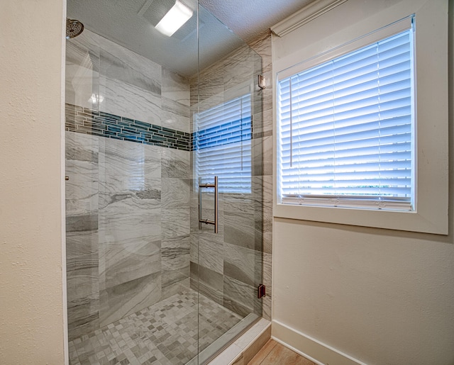 bathroom featuring tiled shower and a wealth of natural light